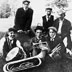 Fotografie Colgatovy kapely z roku 1900. Avery sedí uprostřed a drží v ruce kornet.
